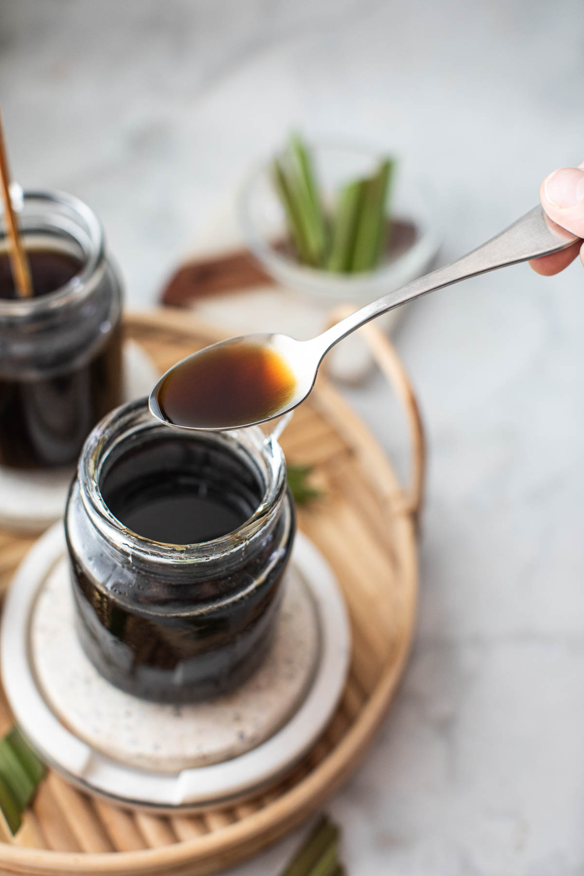 Spoon lifting brown sugar syrup over a jar.
