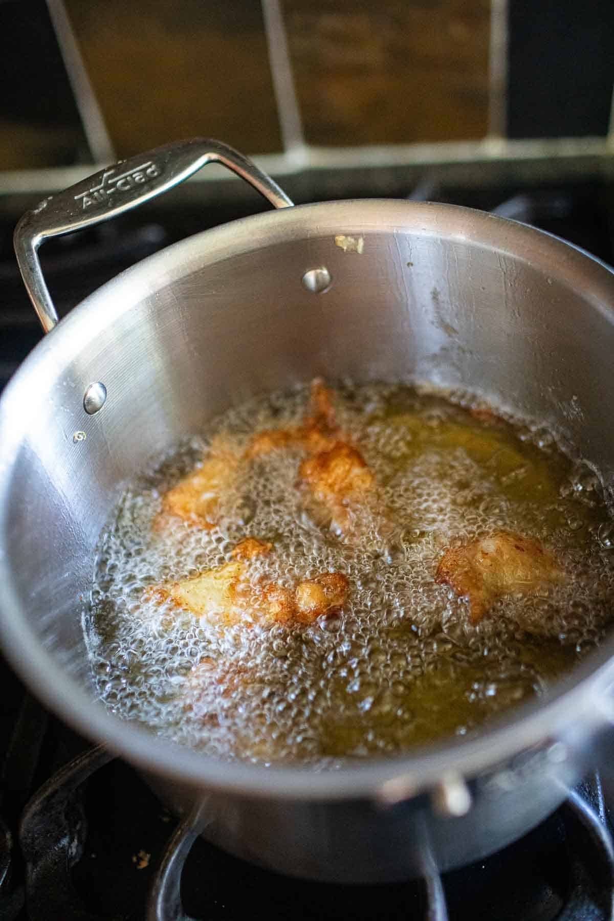 Thai fried chicken wings in oil.