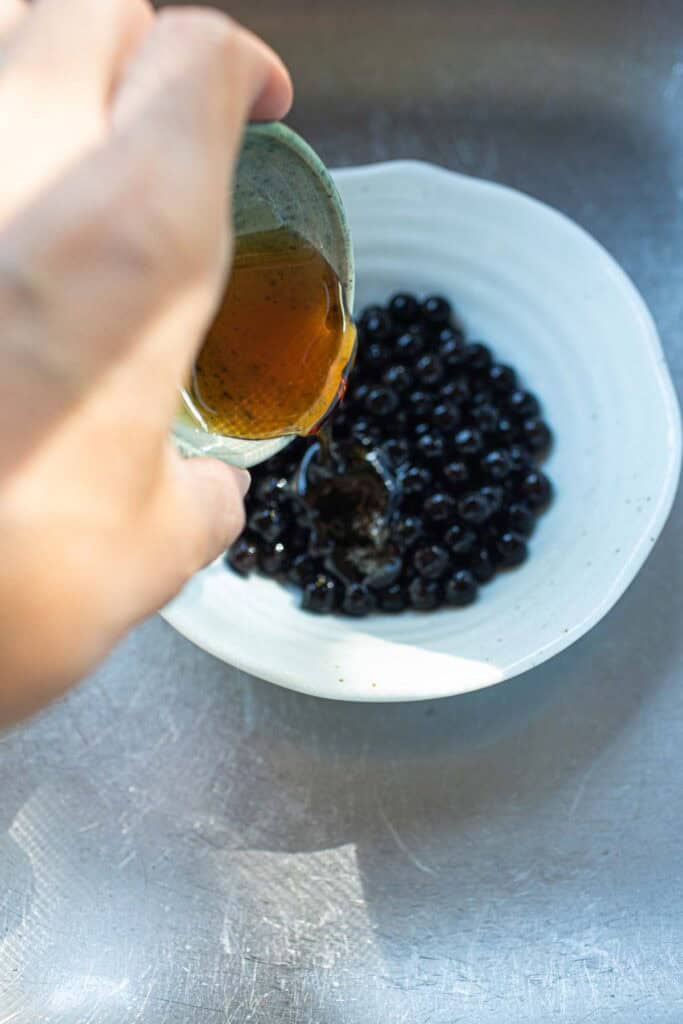 Adding honey to Tapioca pearls in a bowl.