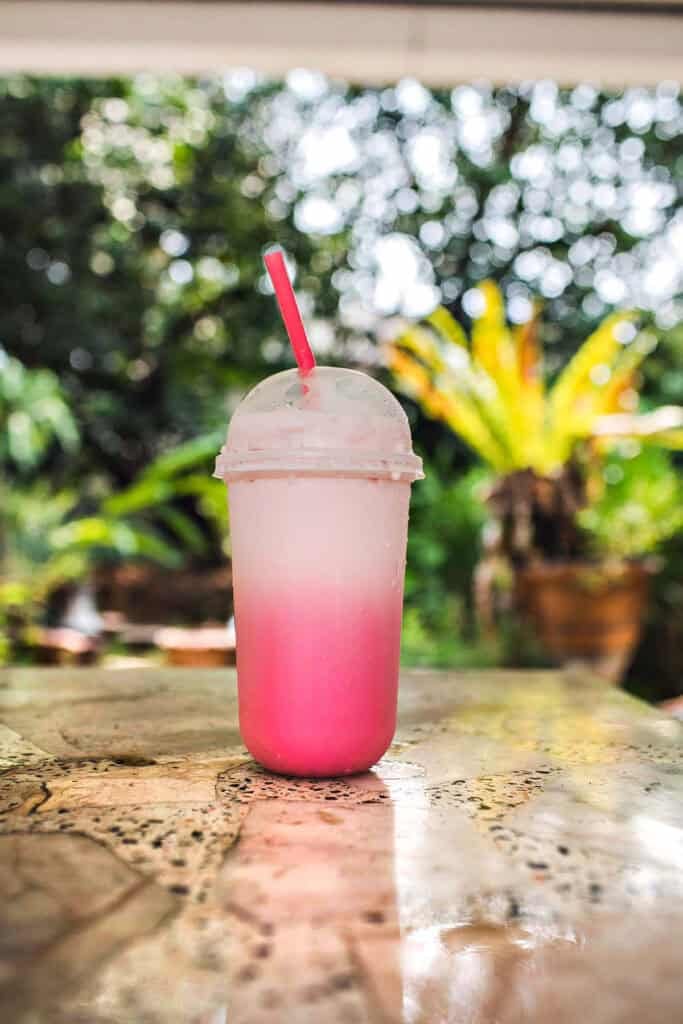 Thai pink drink in a plastic cup with lid. 