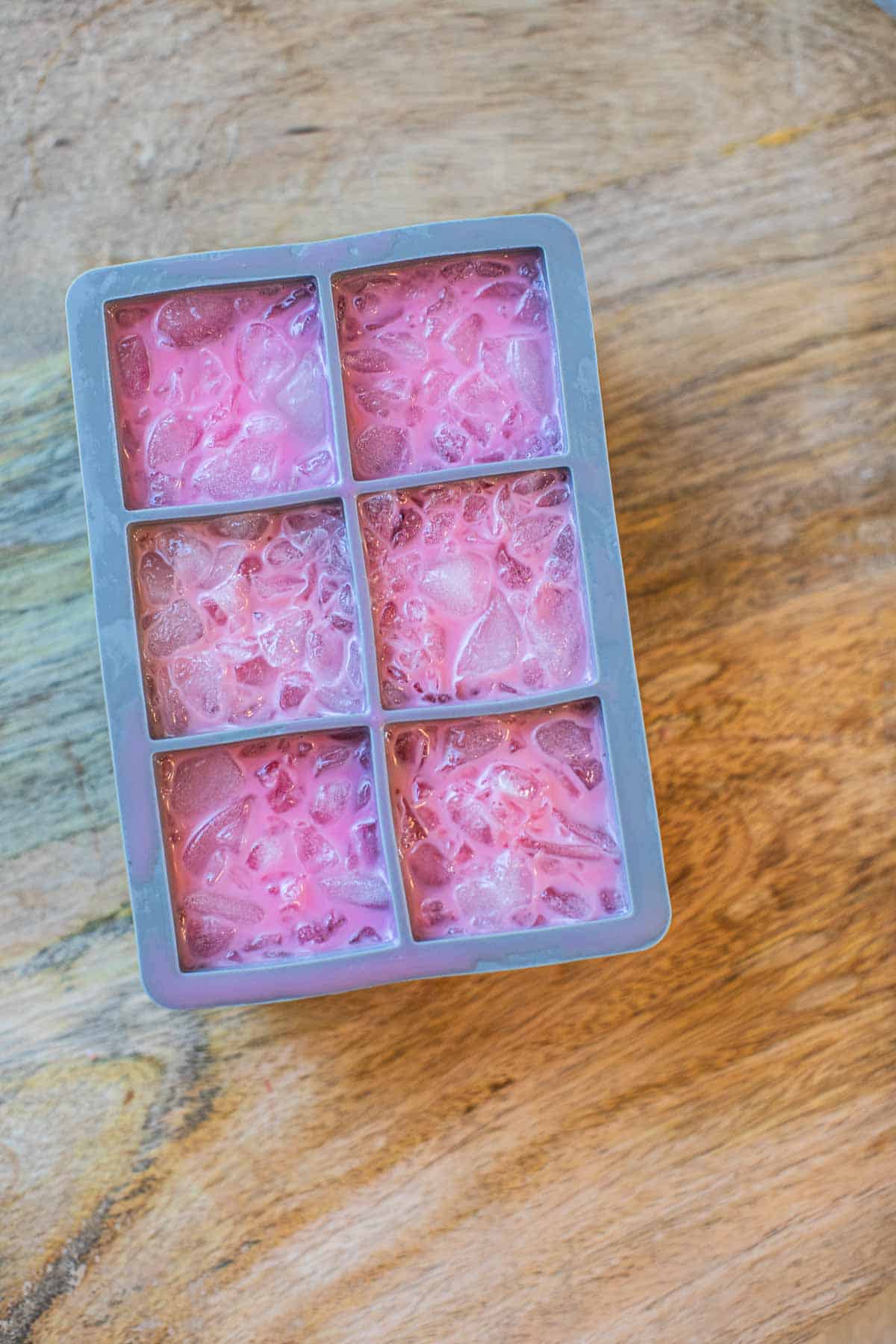 Pink drink in ice cube tray.