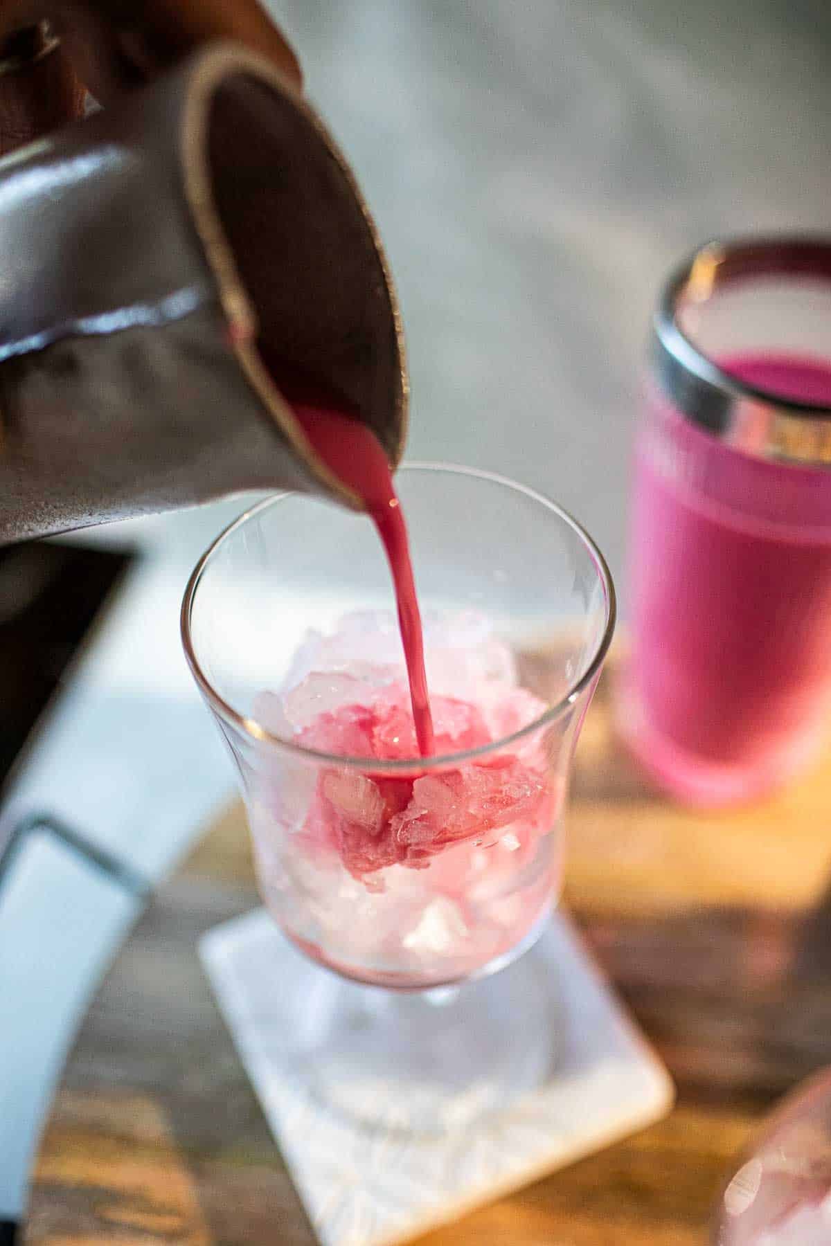 Thai pink milk pouring into crushed ice.