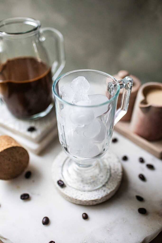 Coffee pouring over a glass of ice.