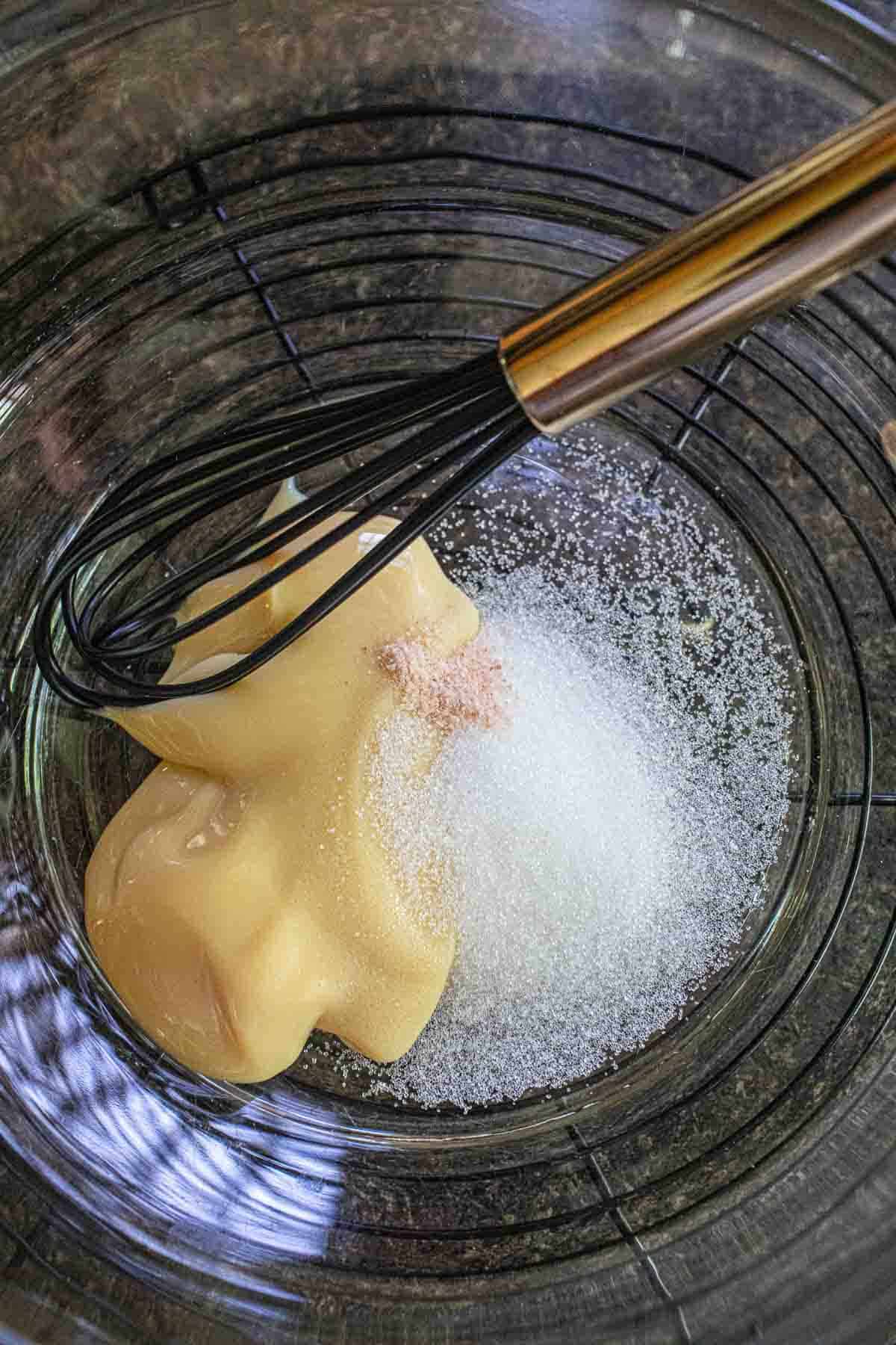 Condensed milk, sugar and salt in a glass bowl.