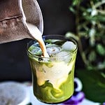 Evaporated milk pouring into green tea.