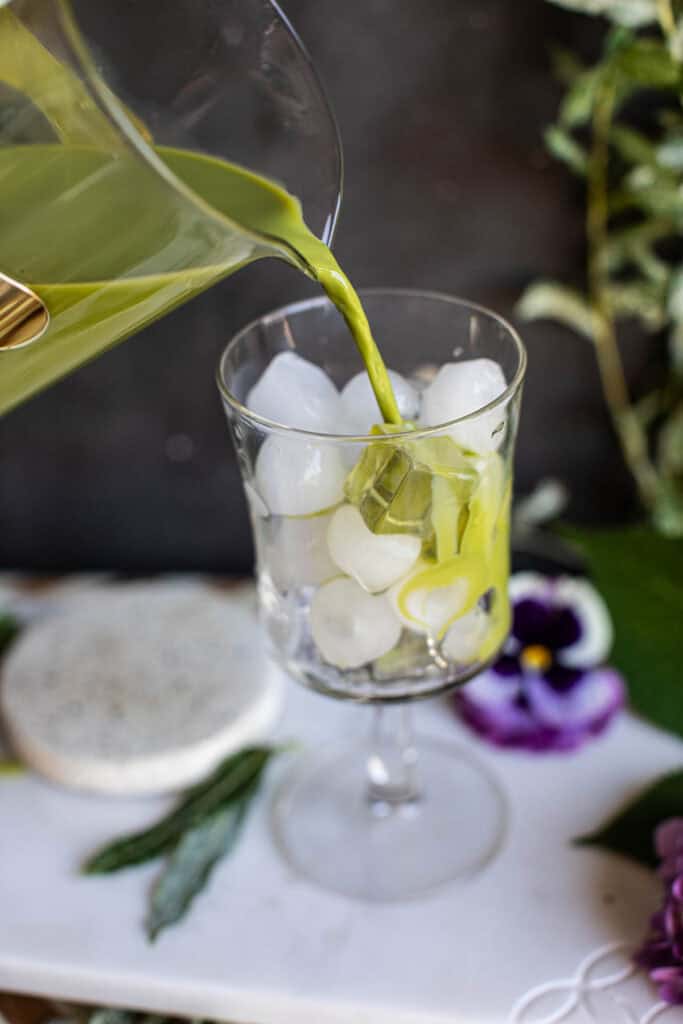 Green tea pouring into Ice cubes in glasses. 