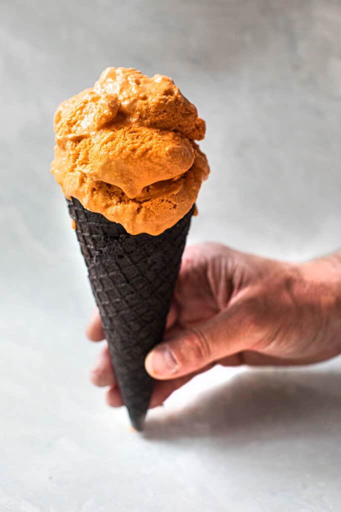 Thai ice cream in a cup in a black cone.