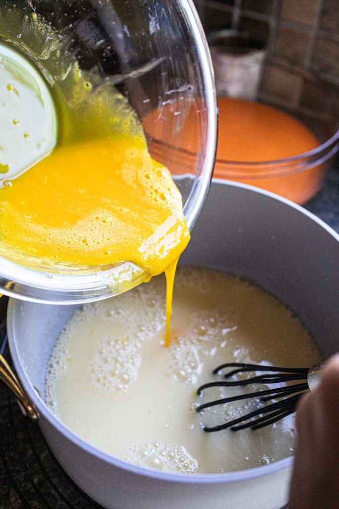 Eggs yolk pouring into coconut milk. 