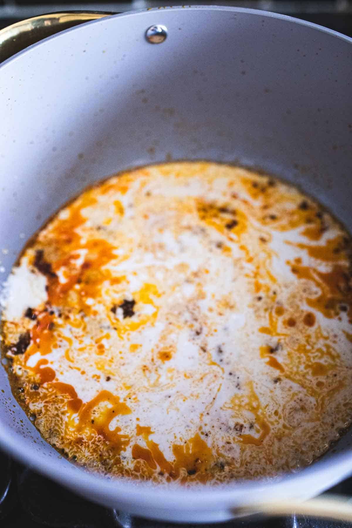 yellow curry paste and coconut milk in a pan.