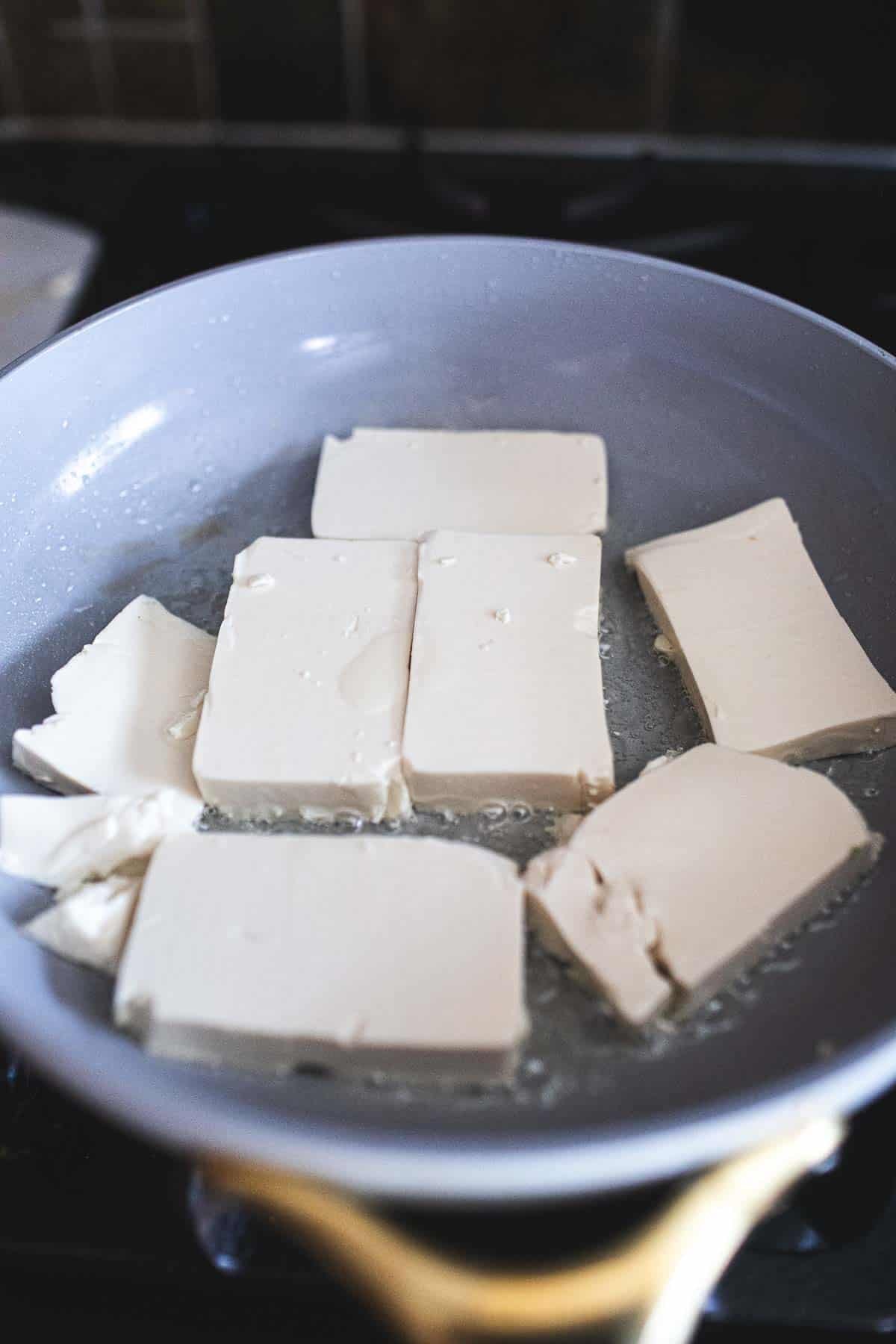 Frying tofu in a pan. 