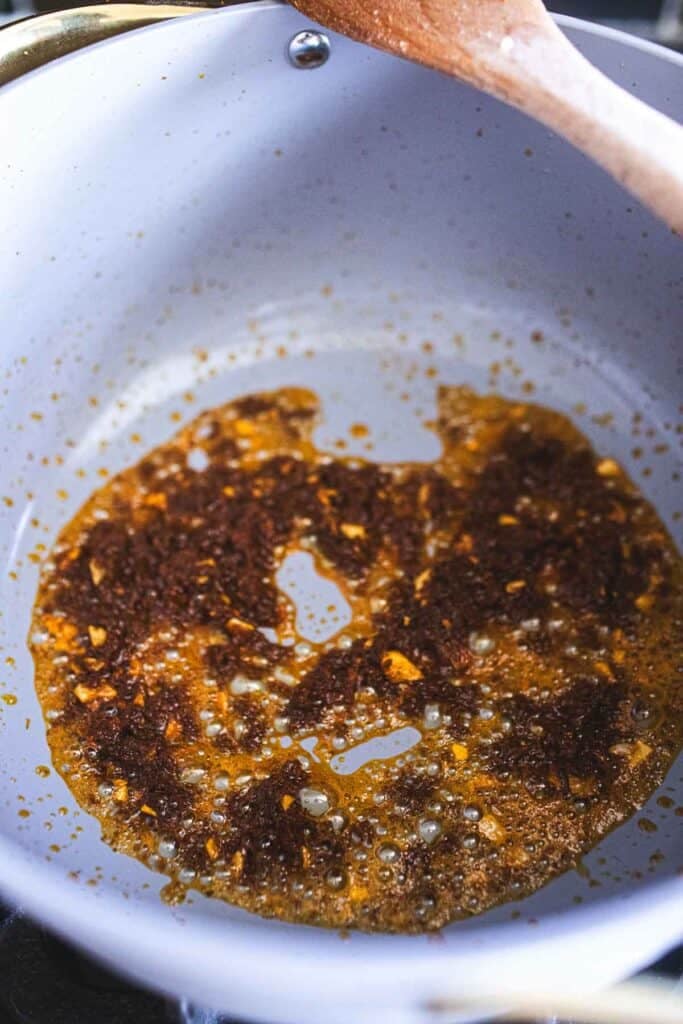 frying garlic and curry paste in a pan. 