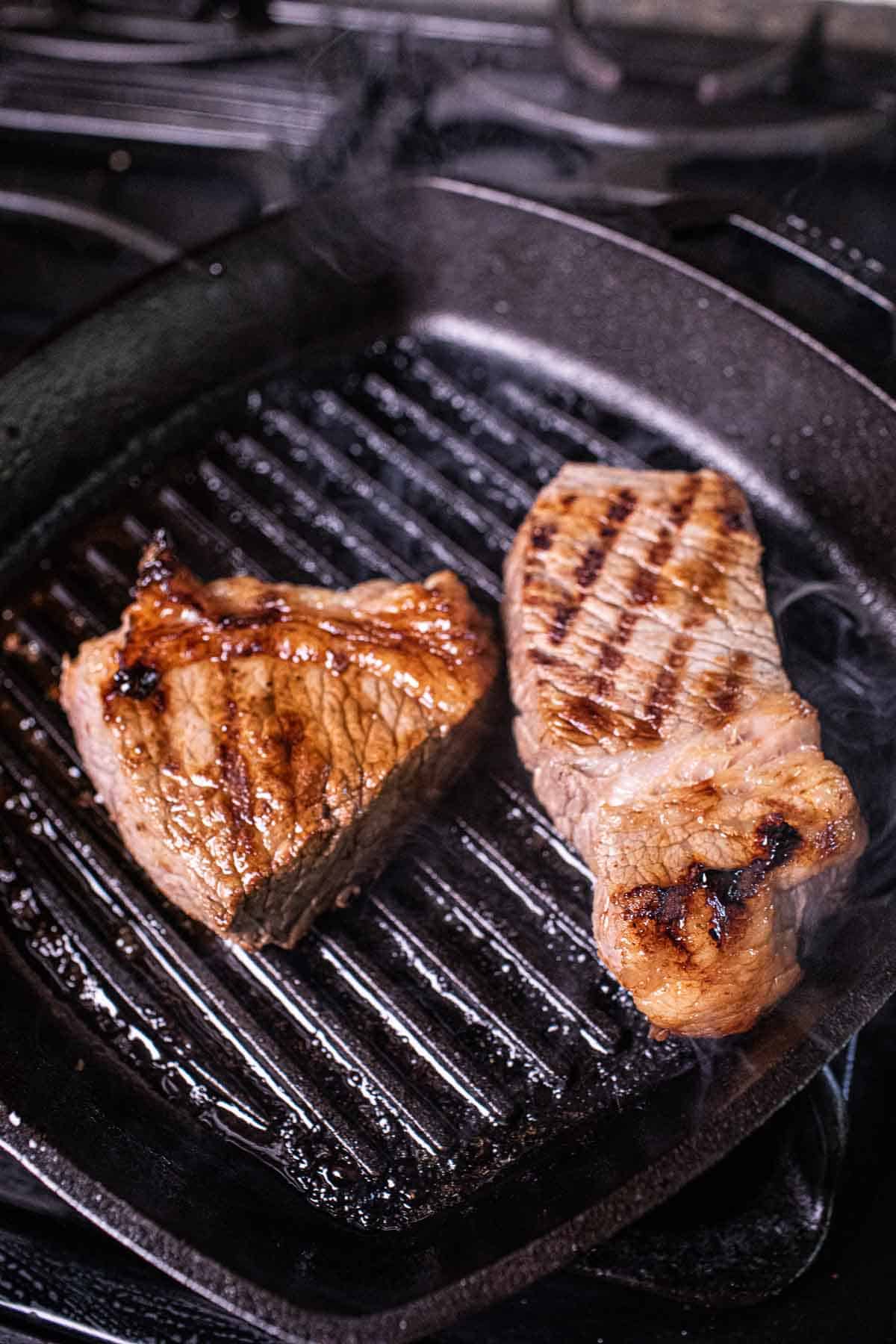 Beef cooking on a grilling pan. 