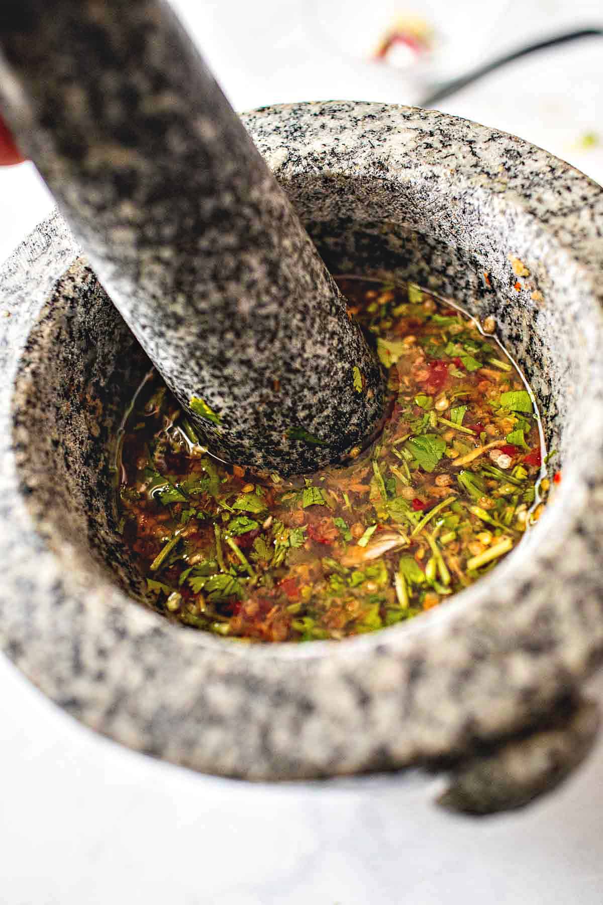 Jeow Som in a mortar with a pestle. 