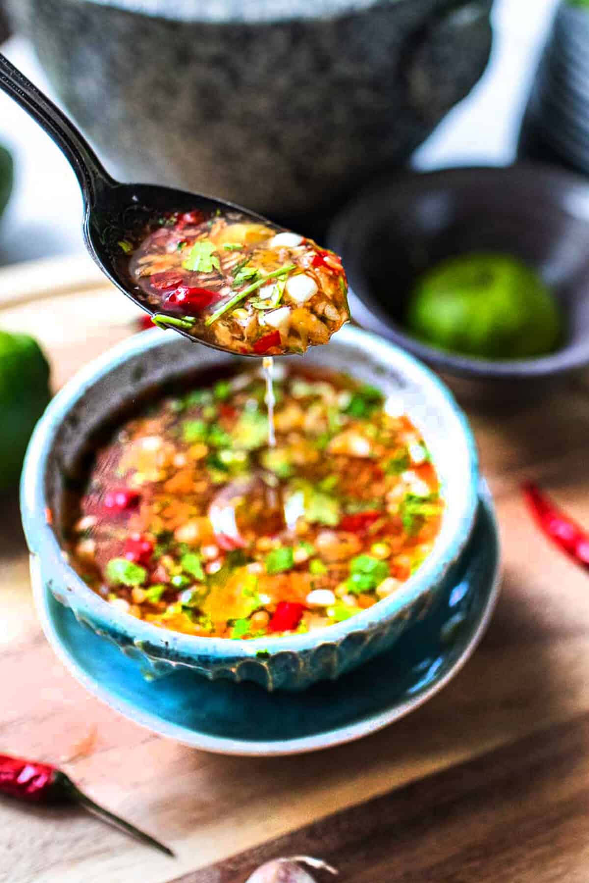 A spoon lifting Jeow Som from a bowl. 