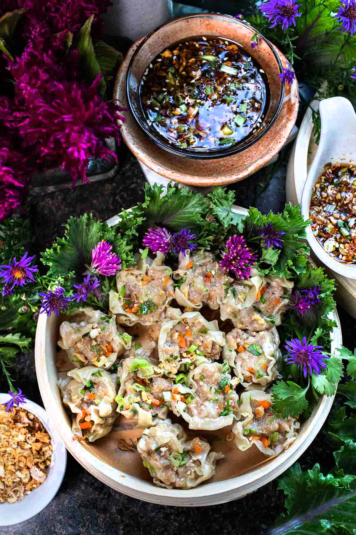 Kanom Jeeb dumplings in a serving plate with sauce. 