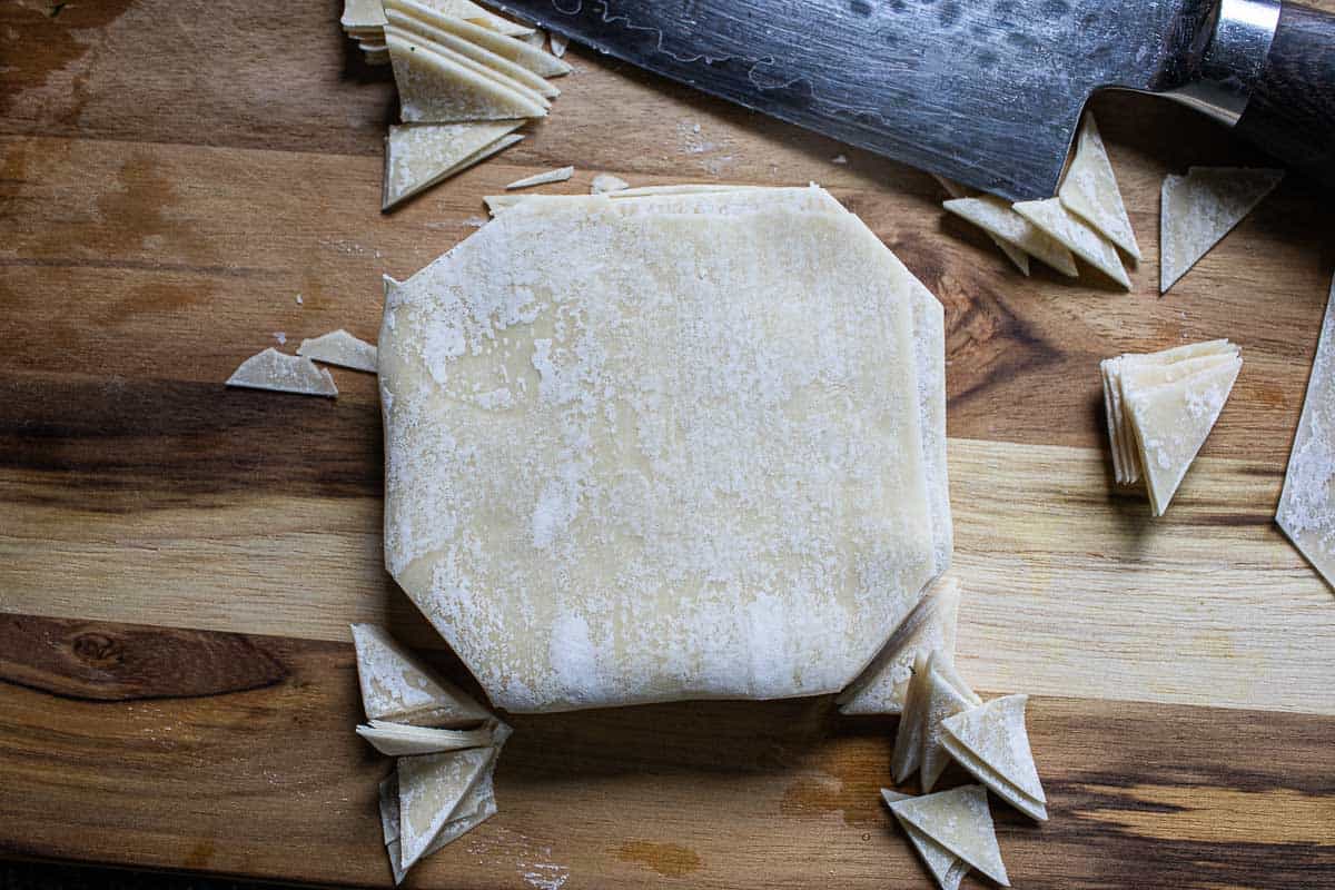 Wonton wrappers on cutting board. 