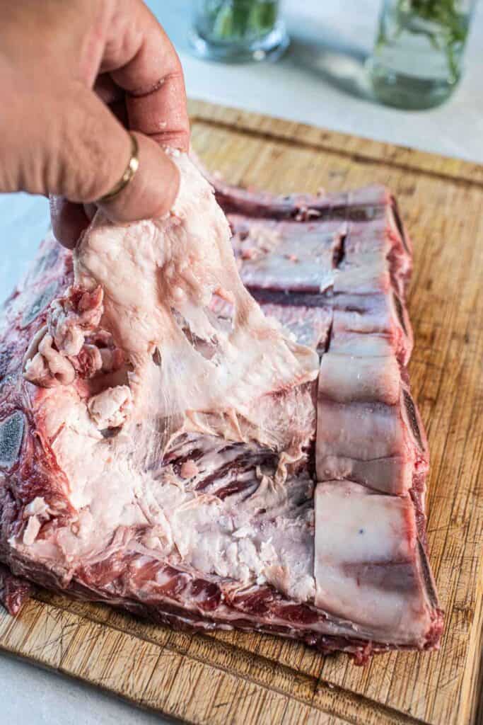 Beef back ribs membrane on a cutting board.