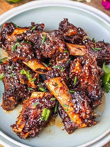 Sticky Asian ribs on a plate on the table.