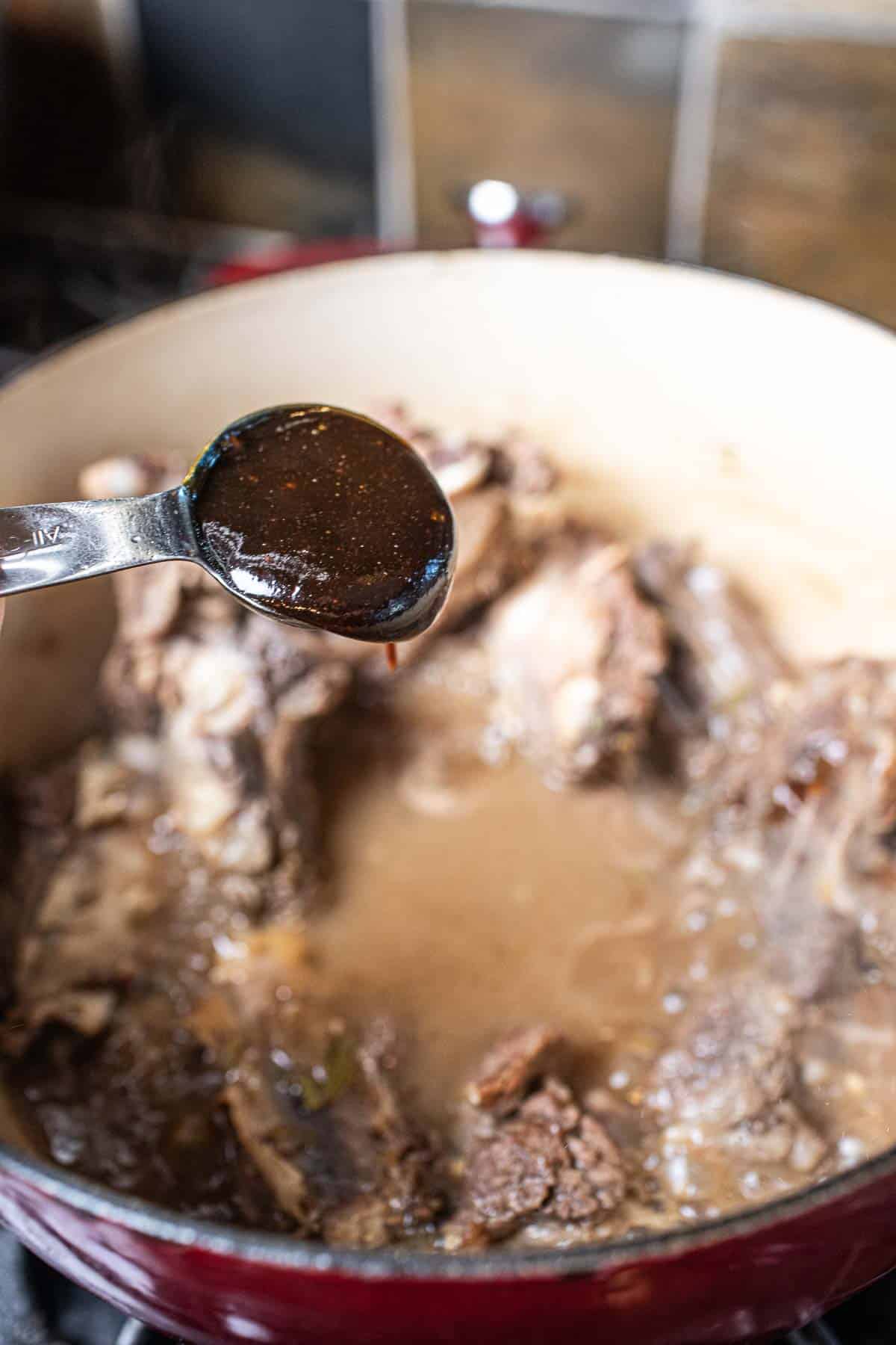 Sauce pouring into a pot of ribs.