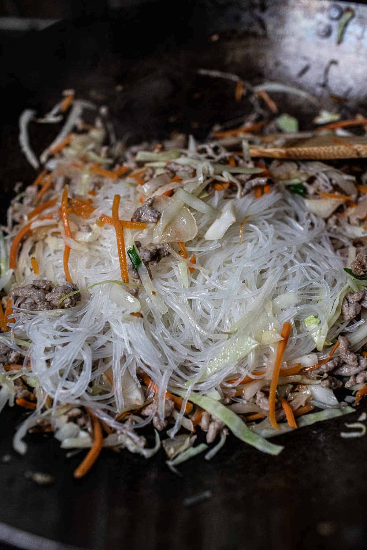 Glass noodles in a wok with cabbage and carrot. 