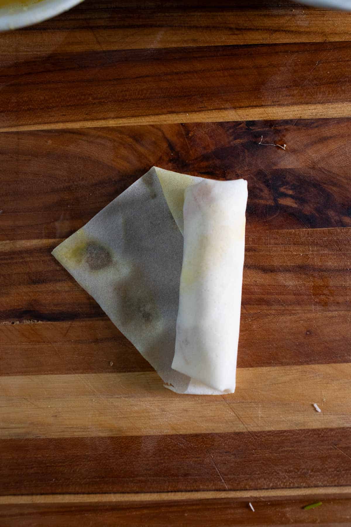 wrapped egg roll on a cutting board. 