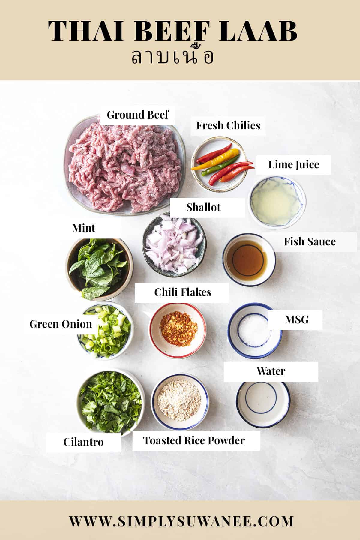 Beef laab ingredients with fresh herbs, chilies, fish sauce and lime juice and toasted rice powder laid out on the table.