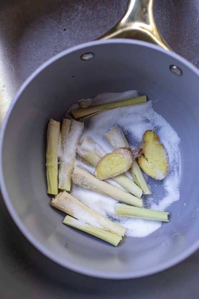 Lemongrass, ginger and sugar in a pot. 