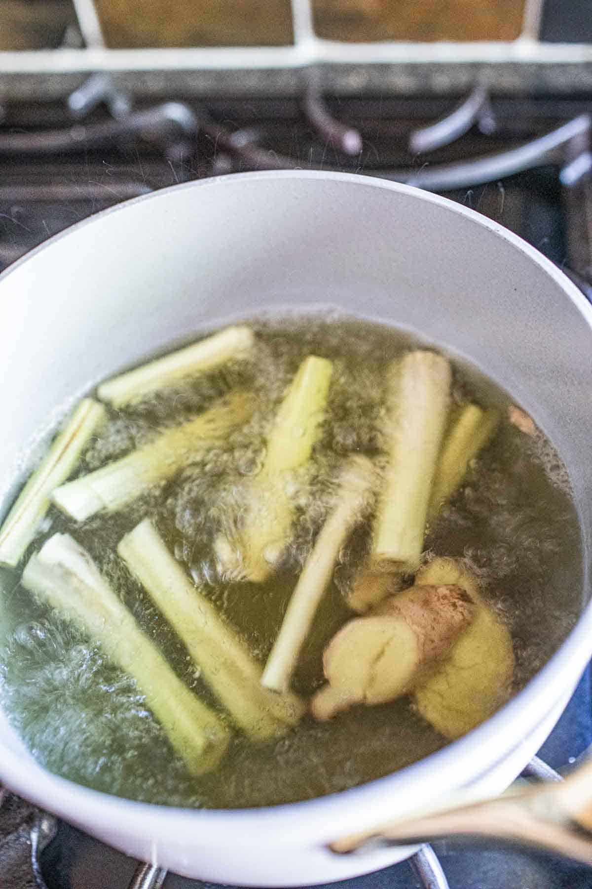 Lemongrass ginger tea boiling in hot water in a pot. 