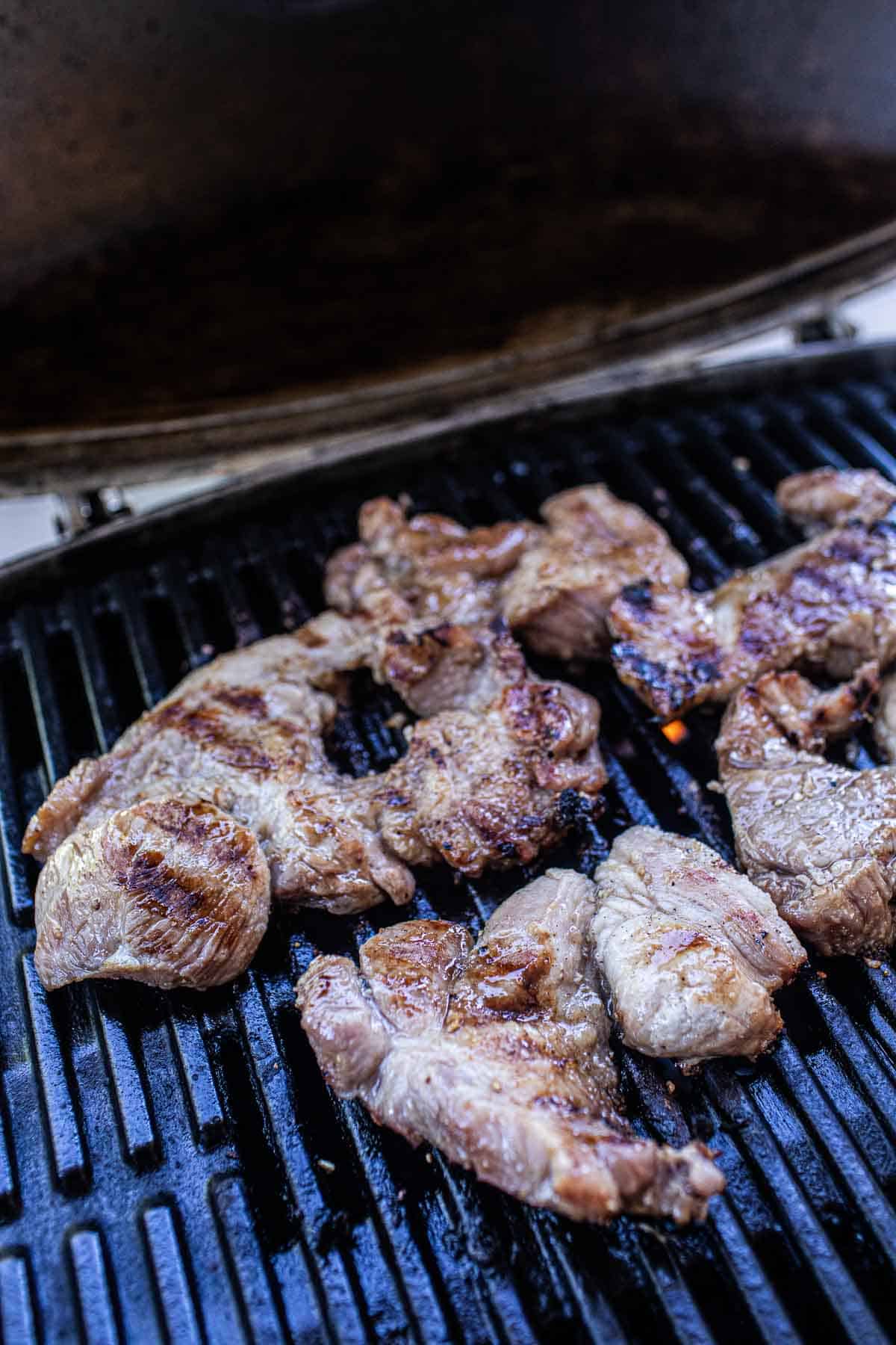 Thai grilled pork neck on the grill.