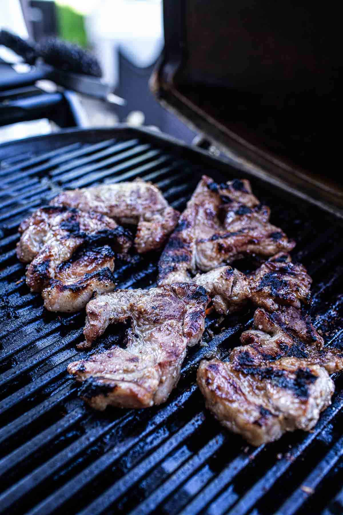 Thai moo Yang pork pieces on the grill.