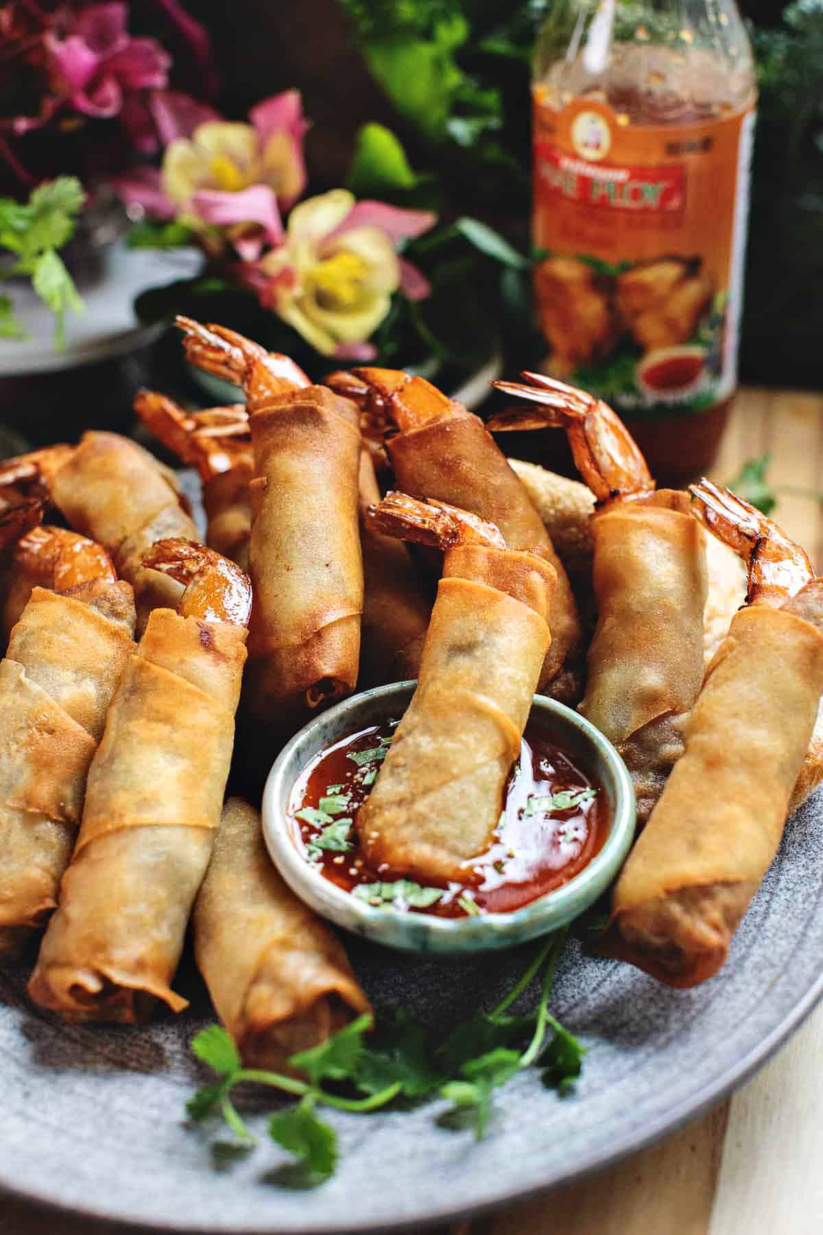 shrimp in blanket on a platter with sweet dipping sauce.