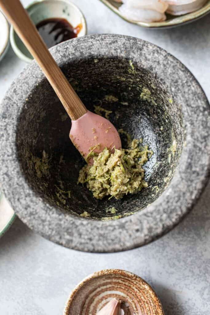 Green paste in a mortar and pestle.