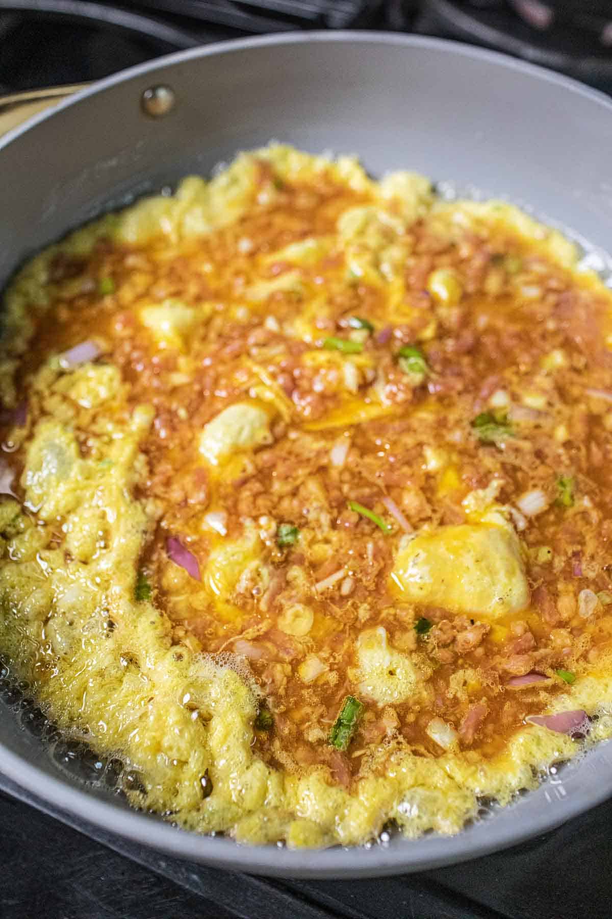 Thai pork omelette in a skillet on the stove. 