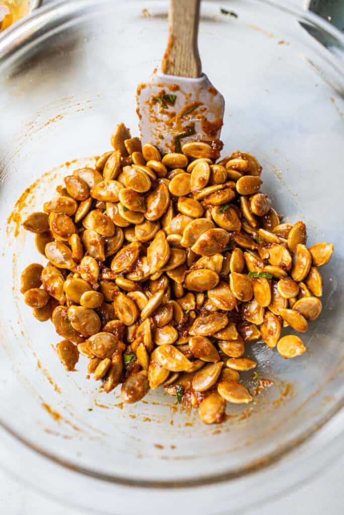 Roasted Pumpkin seeds with tom yum paste in a glass bowl. 