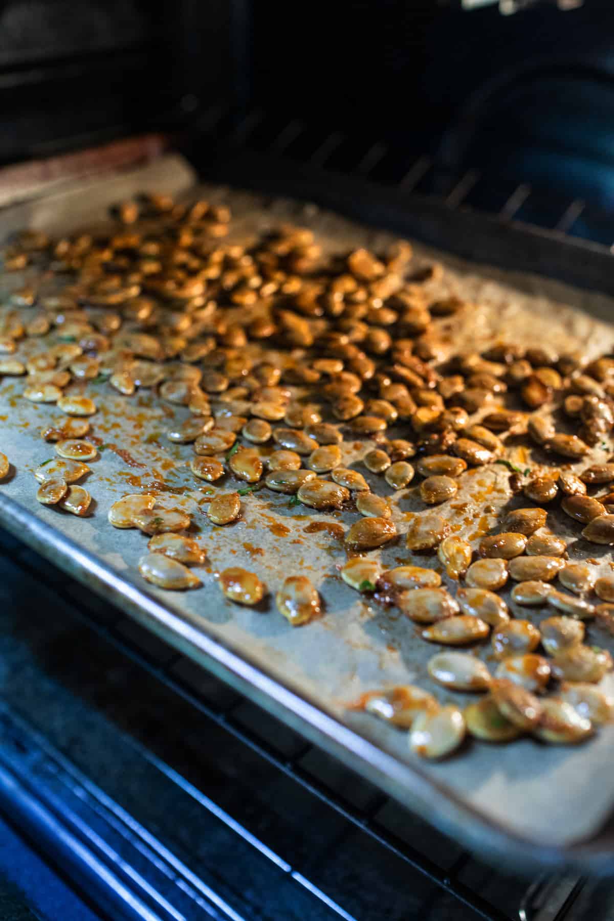 Roasted Pumpkin seeds on a baking sheet in the oven.