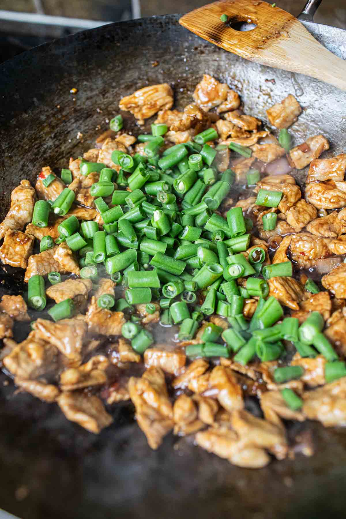 Thai pork Pad kra pao with green beans in a wok. 