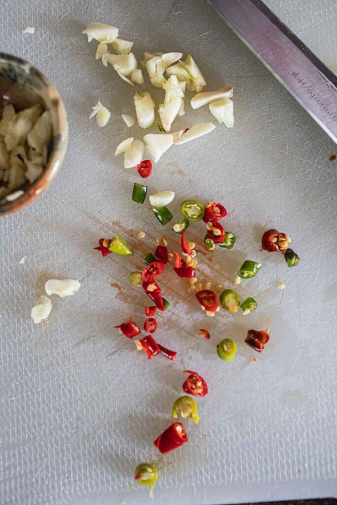 Chopped Garlic, and chilies on a cutting board. 