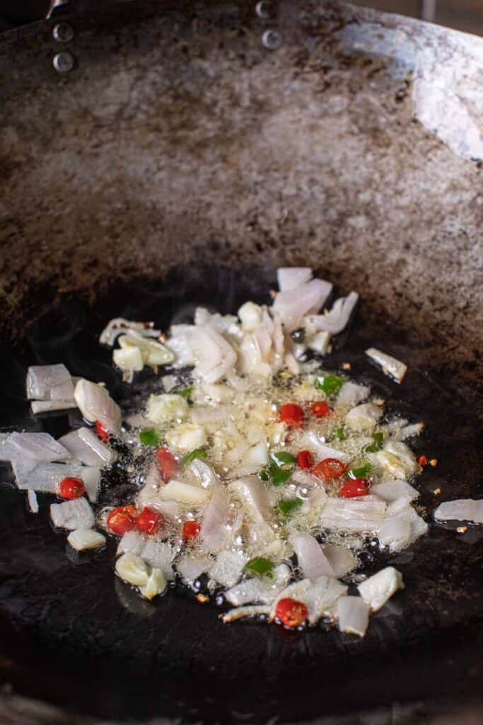 Garlic, shallot and chilies frying in a pan. 