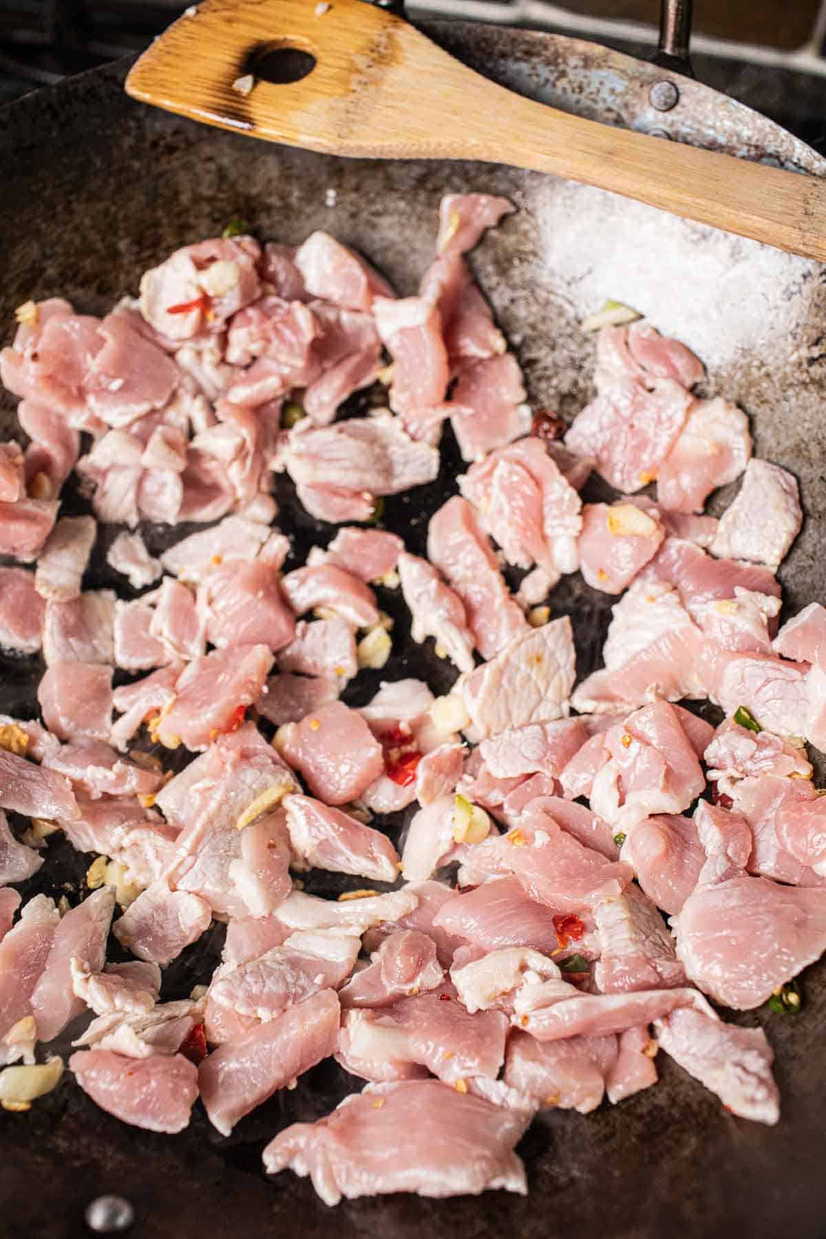 Pork slices cooking in a wok. 