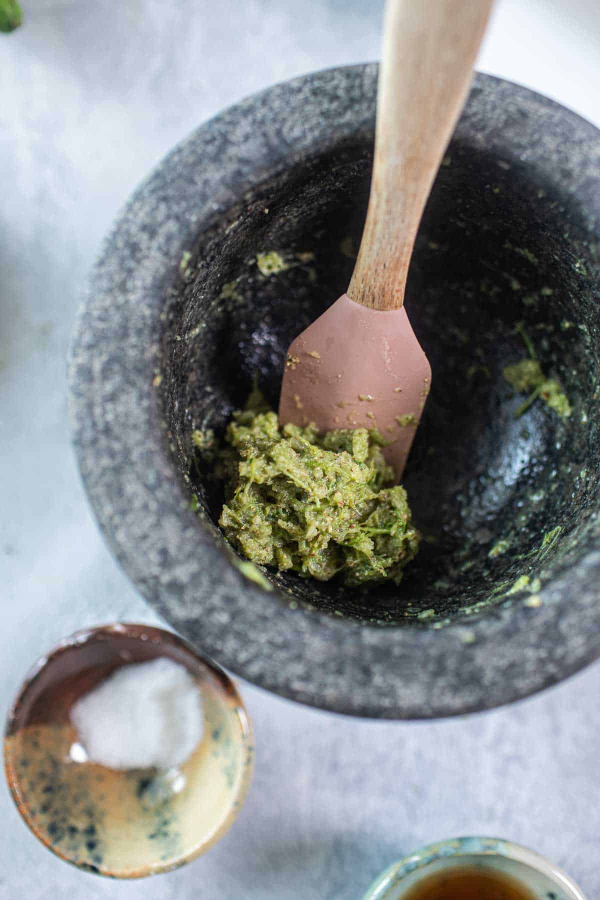 Thai green paste in a mortar with a spatula.