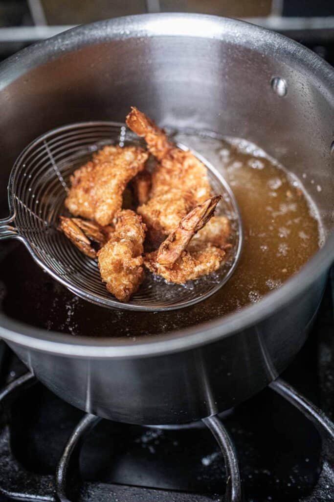 fried butterfly shrimp in oil. 