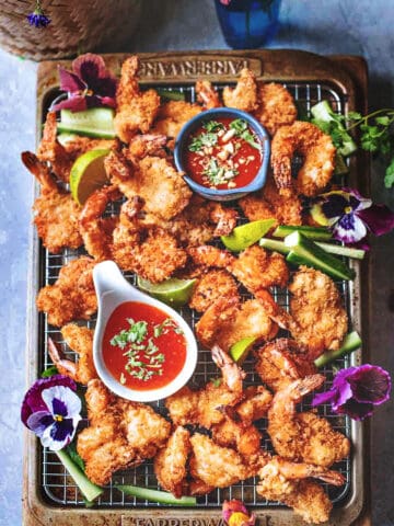 butter fly shrimp on a tray with dipping sauces.