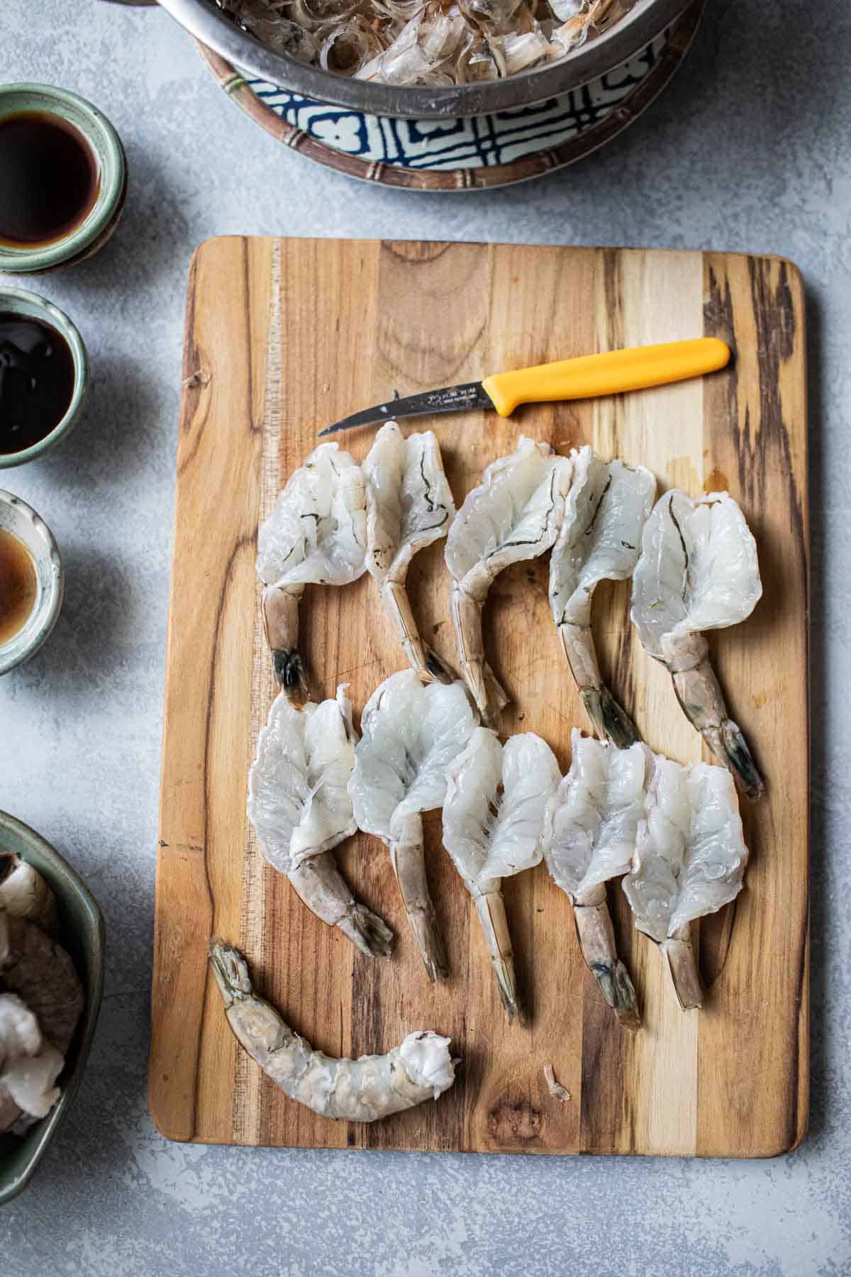 butterflied shrimp on a cutting board. 