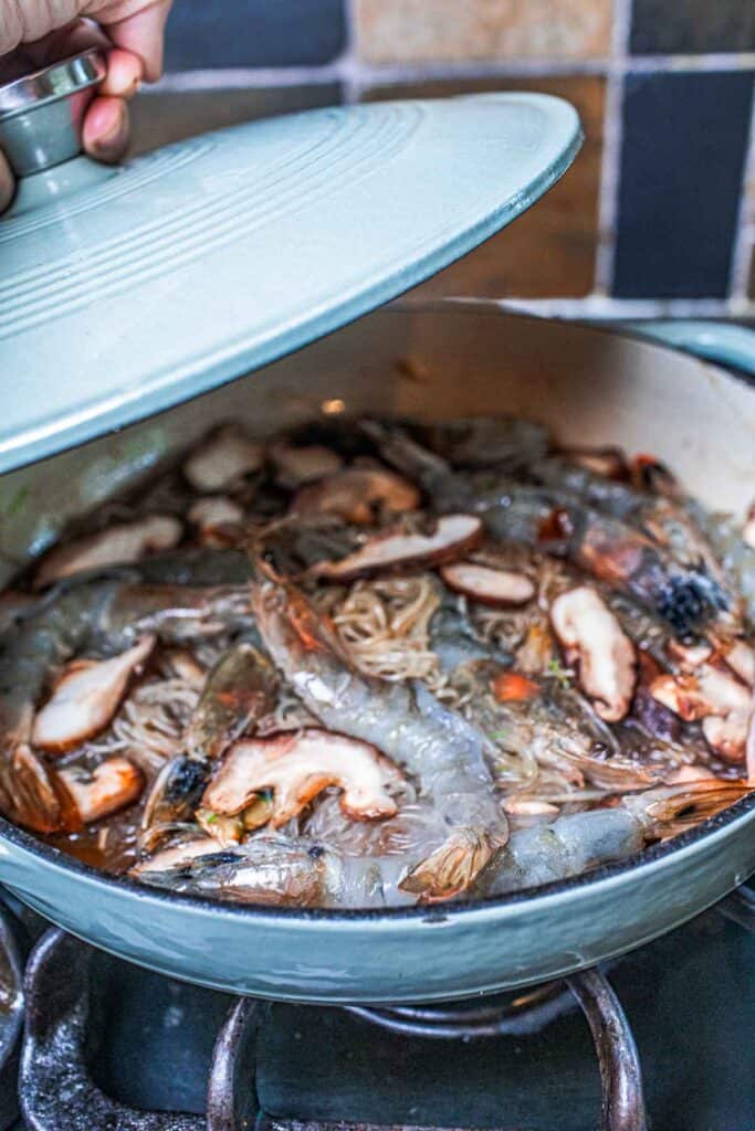 Large prawns in a pan over glass noodles. 