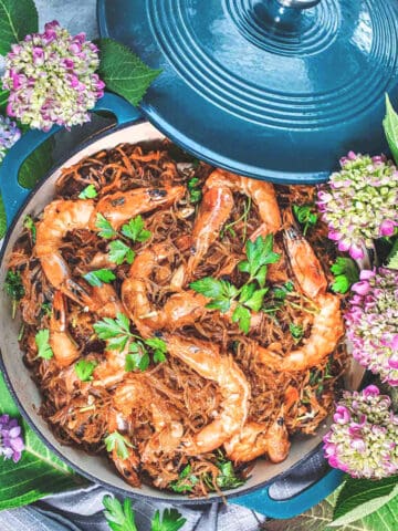 glass noodles with shrimp on a skillet with lid.