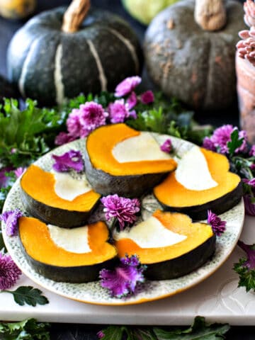 Thai pumpkin custard in slices on a plate with flowers garnish.