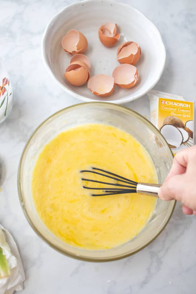 hand whisking Eggs in a bowl.