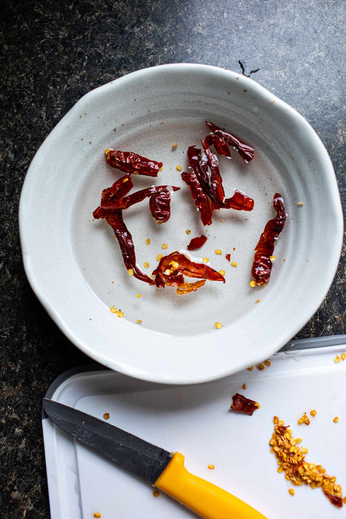 Dried chilis soaking in water in a bowl. 