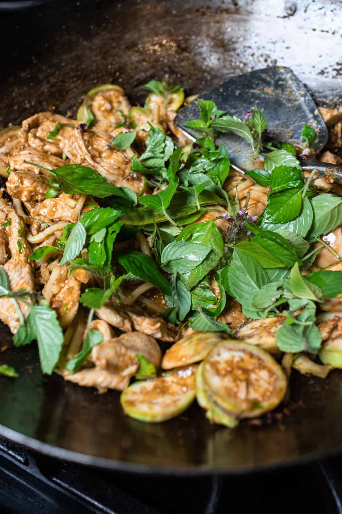 Basil over pad ped chicken stir fry in a wok. 