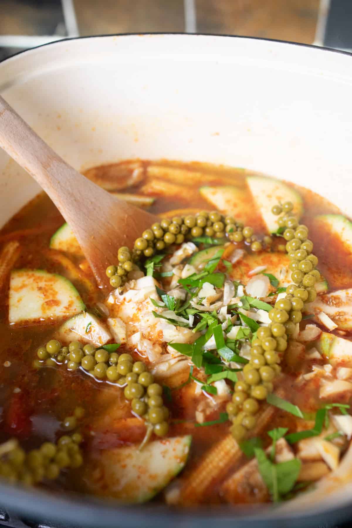 Herbs inside a pot of jungle curry with vegetables. 